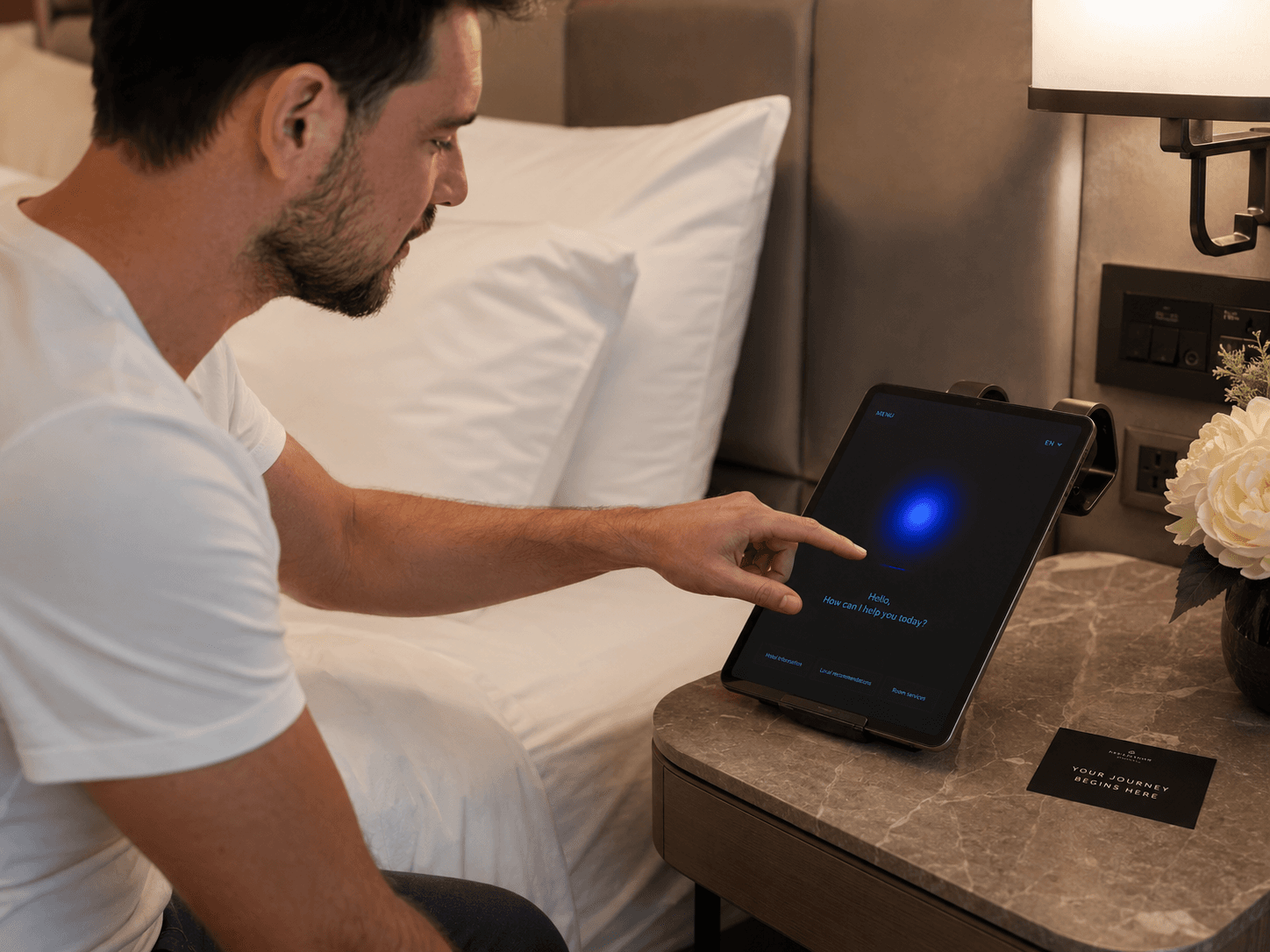 Guest using the in-room Sysist tablet on a nightstand